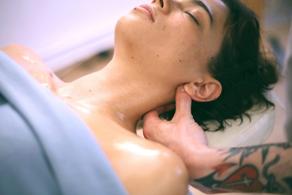 Hand cradling the neck during release work, soft skin and morning light